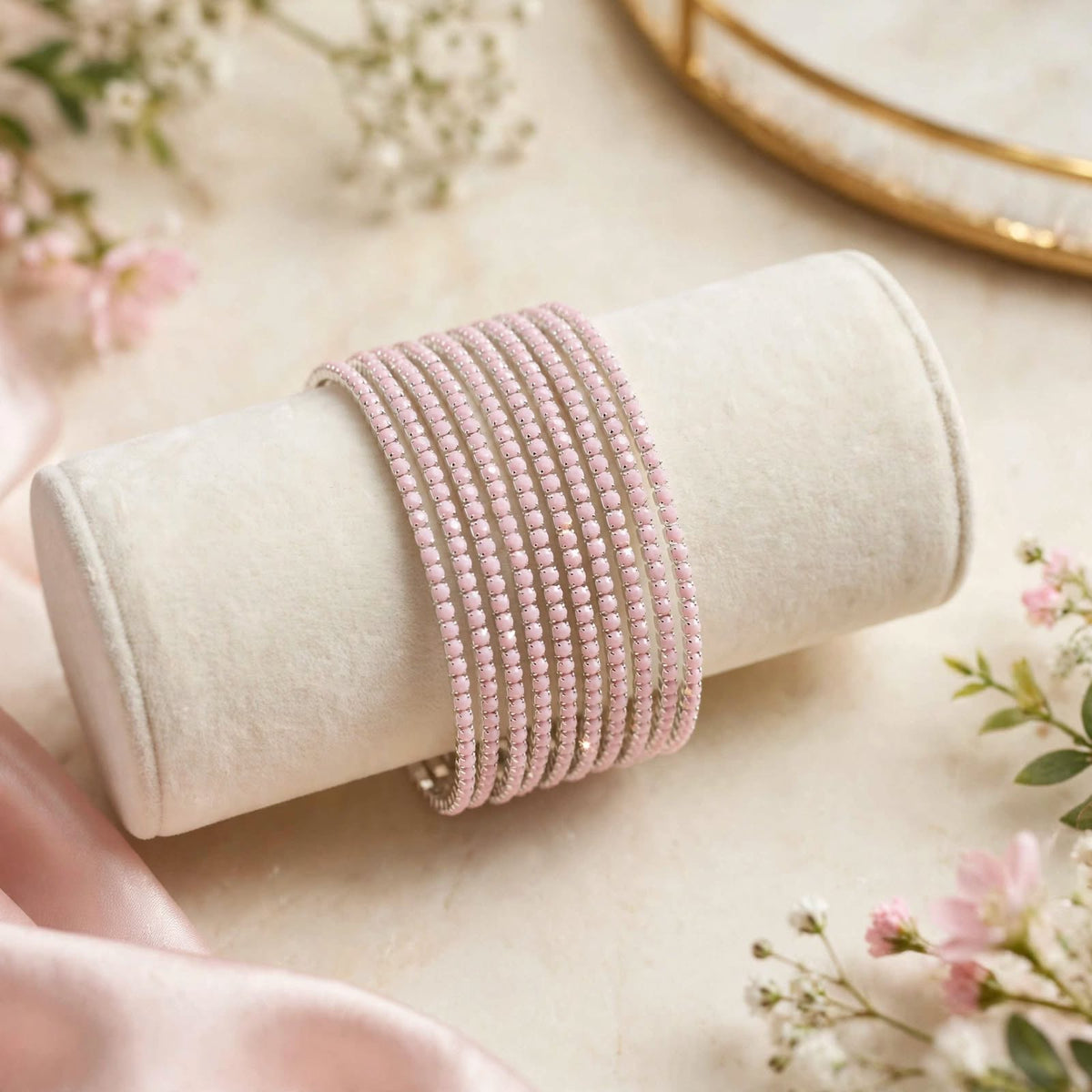 Pink Rhinestone Elastic Bracelet Set of 6 on velvet display roll with floral backdrop