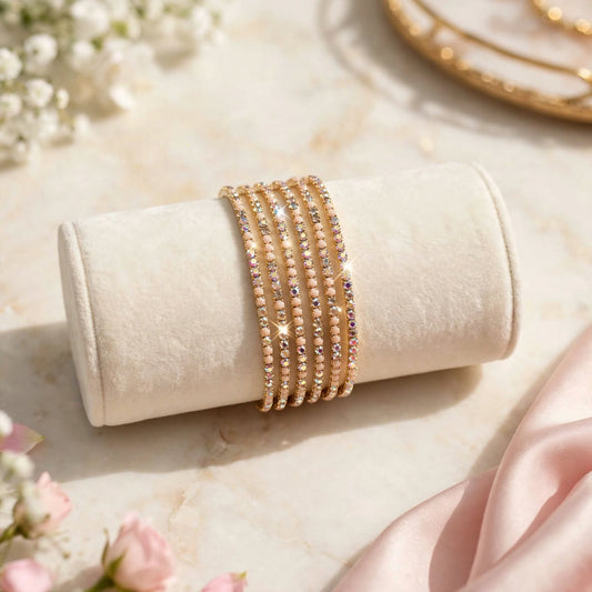 Gold Rhinestone Elastic Bracelet Set of 6 on velvet display roll with floral backdrop