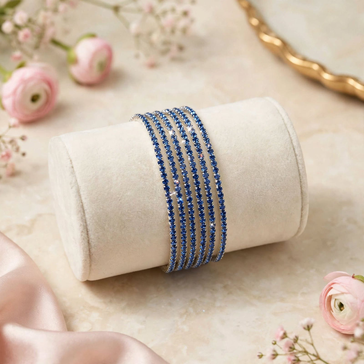 Royal Blue and Silver Rhinestone Elastic Bracelet Set of 6 on velvet display roll with floral backdrop