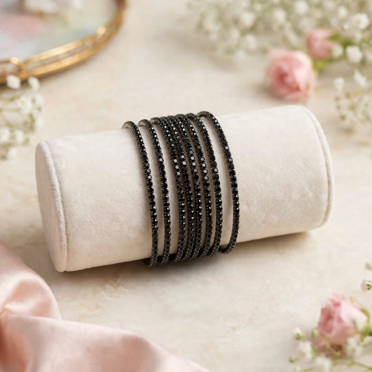 Black Rhinestone Elastic Bracelet Set of 6 on velvet display roll with floral backdrop