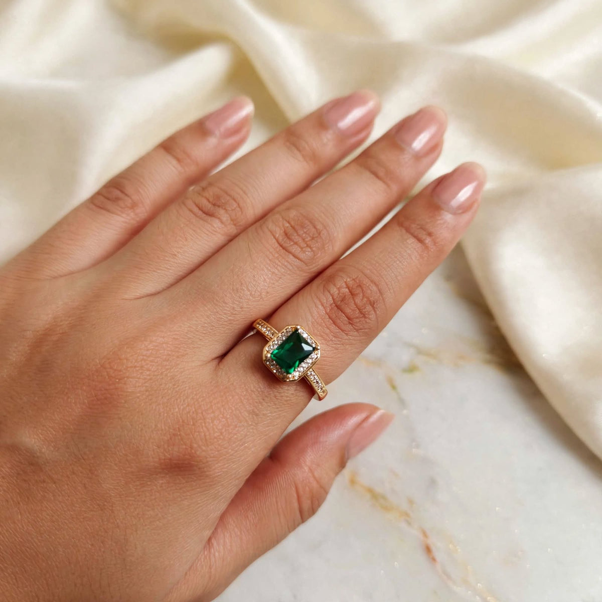 Emerald Green Emerald-Cut Crystal Halo Adjustable Ring in Rose Gold worn on hand with silk backdrop